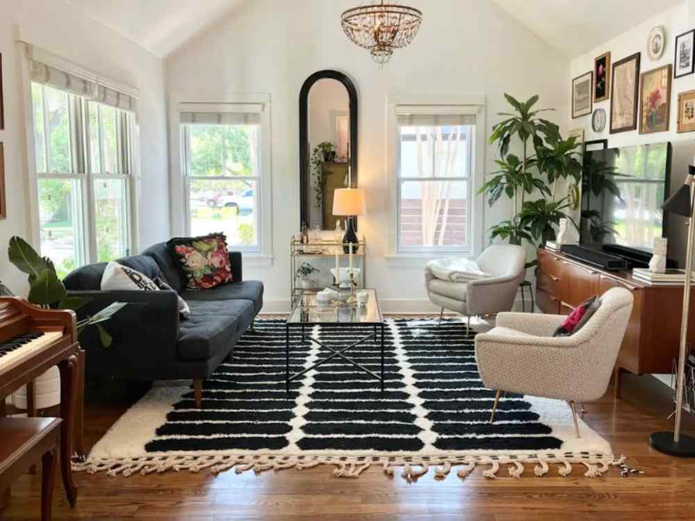 Phòng khách với gương khung đen, dáng vòm cao, đặt cạnh cửa sổ