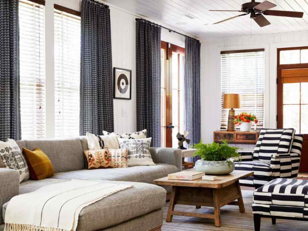 Phòng khách với rèm hai lớp dài từ trần xuống sàn, tạo cảm giác cao thoáng