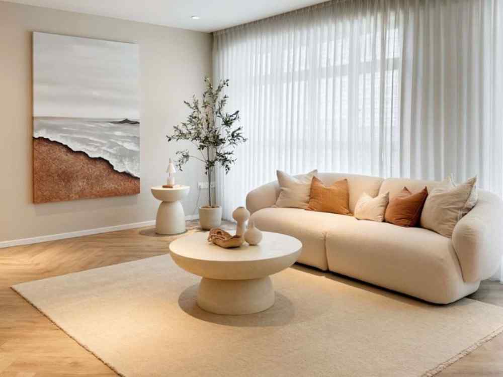 Phòng khách với thảm lớn tone kem trắng kết hợp mặt bàn thấp và sofa sáng