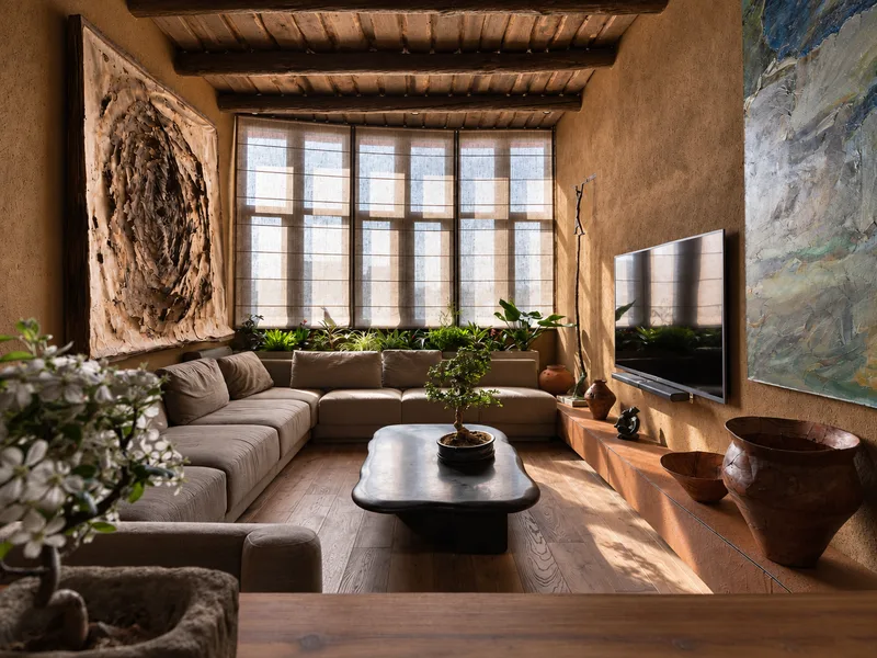 Phòng khách phong cách Wabi Sabi phối sofa vải thô với nội thất gỗ mộc trên nền tường vữa cũ.