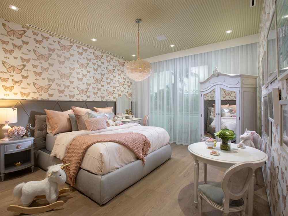 Phòng ngủ bé gái trang trí họa tiết bướm, giường bọc nệm hồng kem cùng bàn trà nhỏ xinh