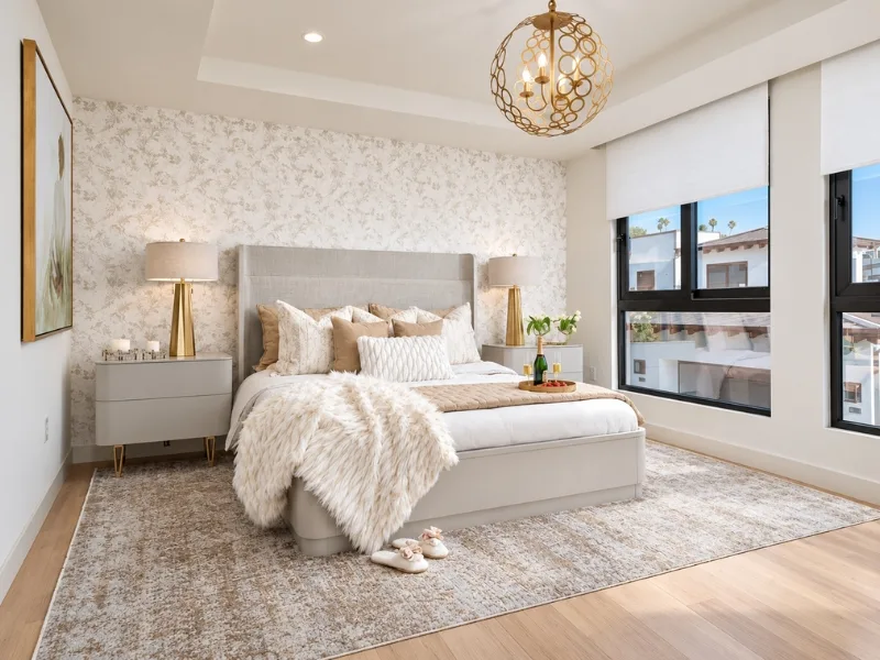 Phòng ngủ phong cách Luxury phối giường bọc nệm sáng màu với đèn thả ánh vàng trong bảng màu trắng kem.
