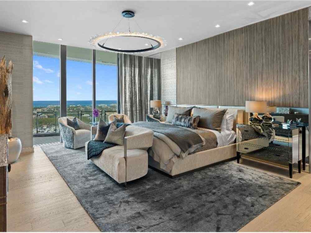 Phòng ngủ master sang trọng với ghế sofa cuối giường, thảm lớn và view hướng biển