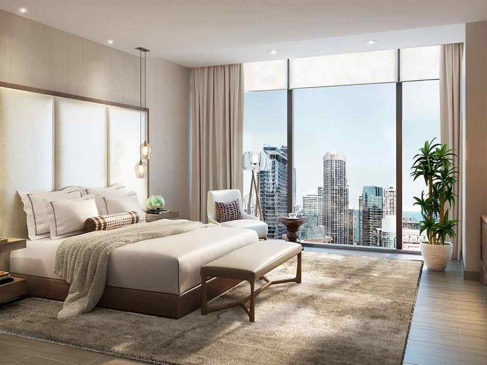 Phòng ngủ master tông be hiện đại với giường thấp gỗ sậm, thảm lông dày