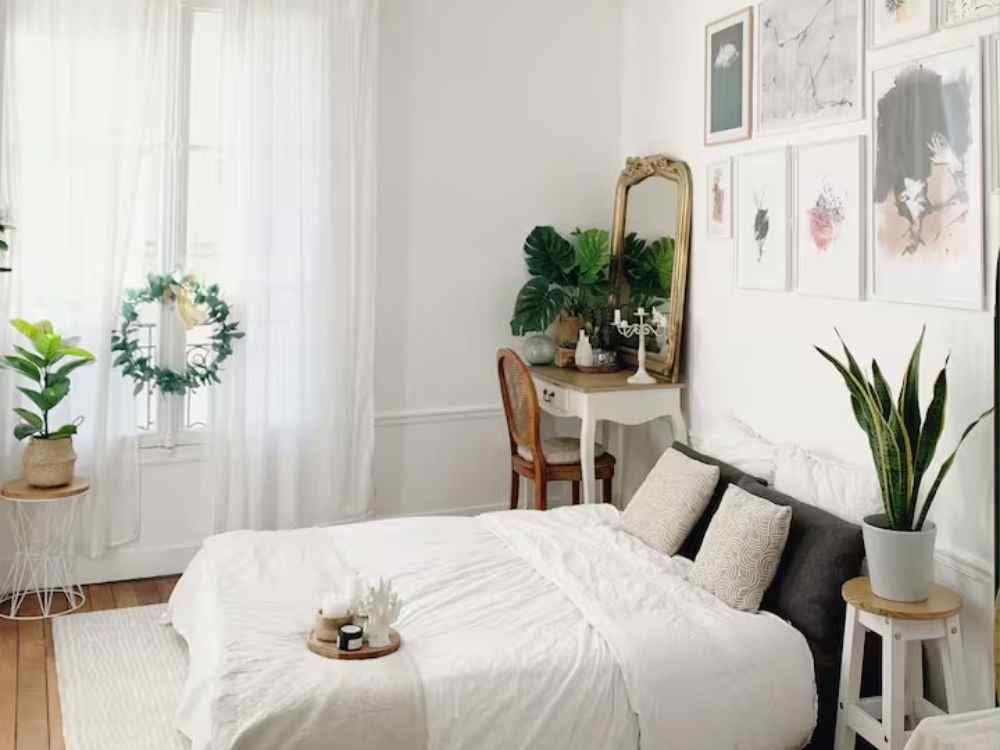 Phòng ngủ tươi sáng phong cách Bắc Âu với rèm trắng, cây xanh và nội thất gỗ sáng màu