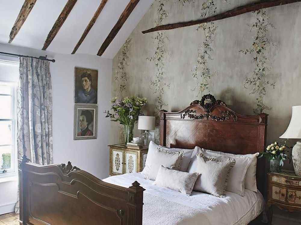 Phòng ngủ vintage gỗ nâu cổ, đầu giường chạm khắc, tường họa tiết dây leo, đèn bàn cổ điển