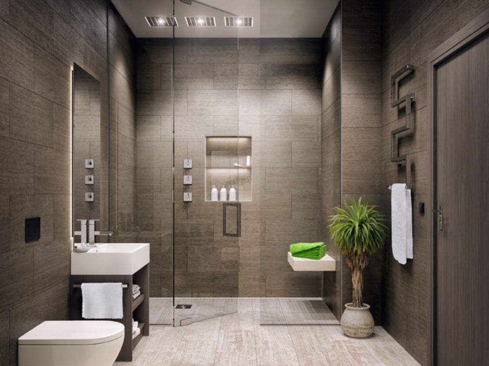 Phòng tắm tông xám ấm, ốp gạch lớn, cây xanh trang trí,