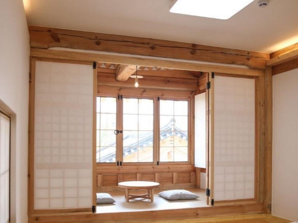 Phòng trà phong cách Nhật Bản với cửa Shoji gỗ, chiếu Tatami và bàn tròn thấp gần cửa sổ