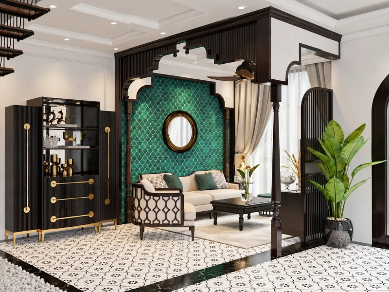 Sảnh thư giãn phong cách Indochine có ghế mây lưng cao đặt trước mảng tường xanh viền gỗ sẫm.