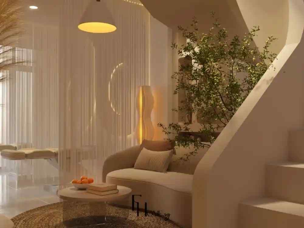 Thiết kế góc thư giãn dưới cầu thang, sử dụng tông màu be trung tính, sofa cong mềm mại, ánh sáng vàng ấm