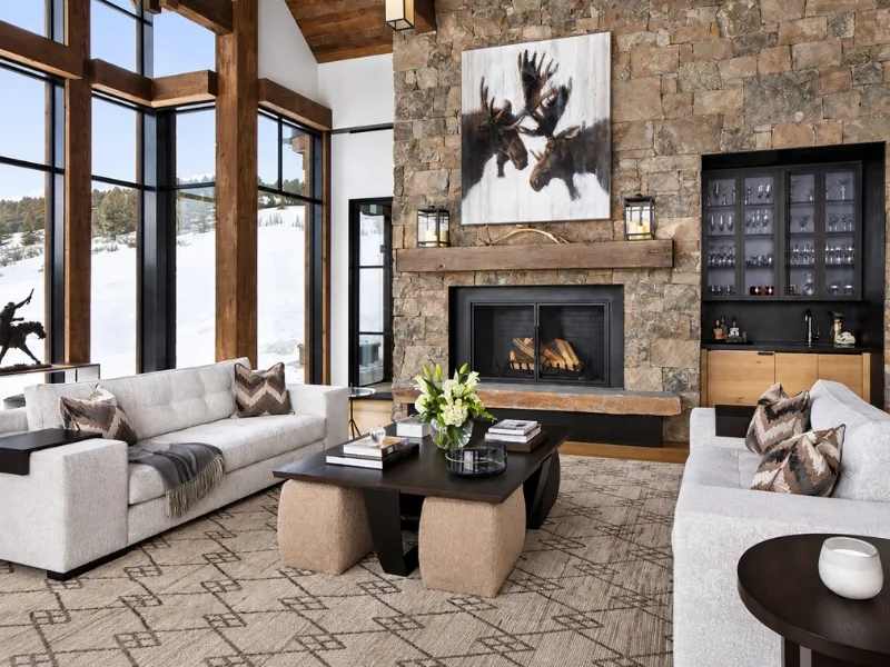 Thiết kế phòng khách phong cách Rustic có lò sưởi trên mảng tường đá cao cạnh cửa kính lớn.
