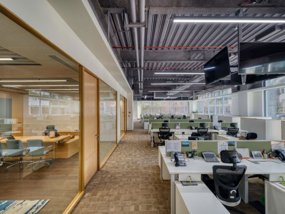 Bàn làm việc nhân viên bố trí ngang hàng với vách ngăn thấp, vừa đảm bảo riêng tư vừa dễ kết nối