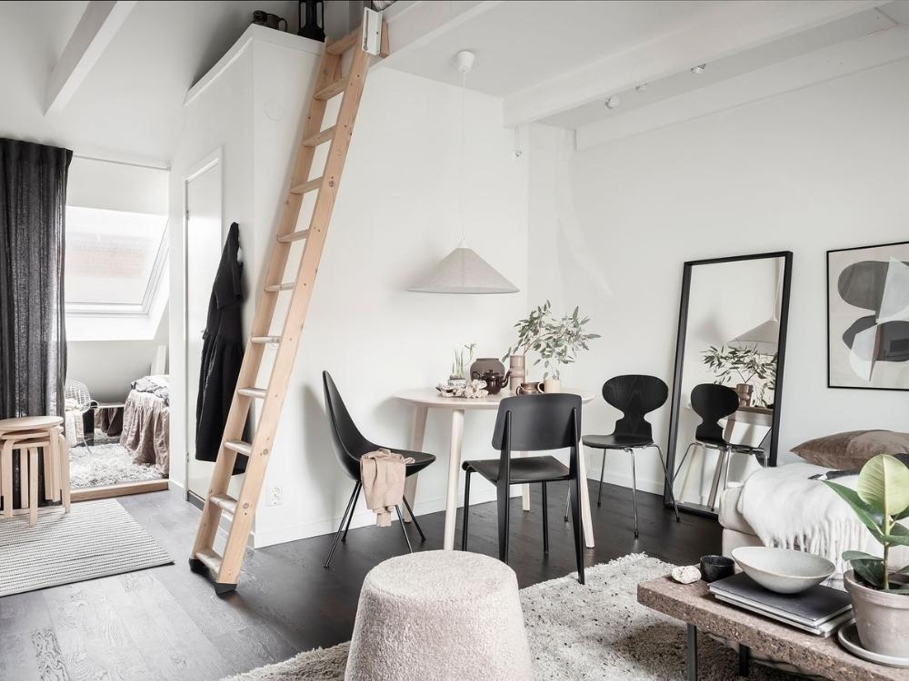 Phòng khách sáng thoáng với gam màu trắng xám nhẹ và nội thất gỗ sáng mang lại cảm giác ấm cúng