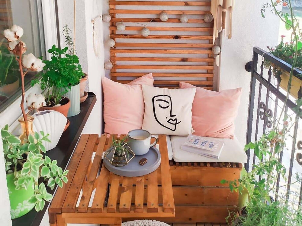 Ban công ấm áp với thảm mềm gối tựa và ánh đèn vàng nhẹ nhàng