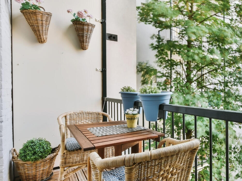 Ban công thoải mái với bàn ghế êm ái và vài chậu cây xanh