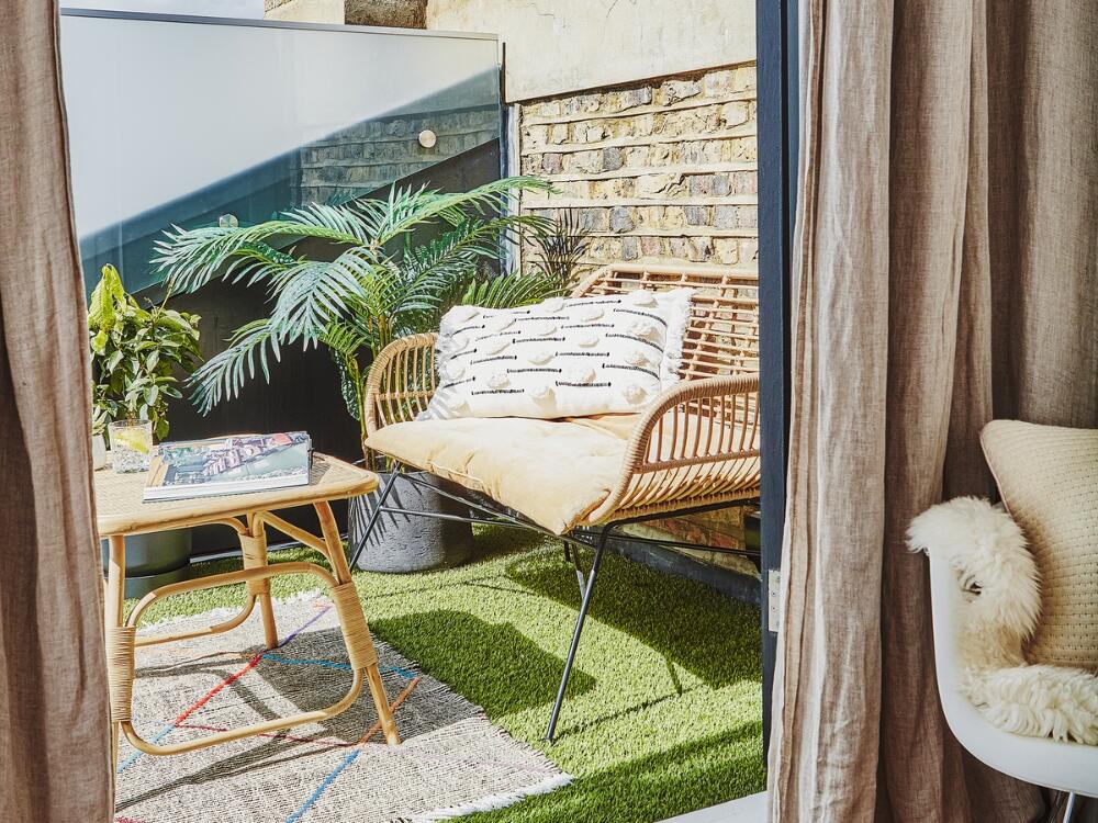 Gương trang trí và chậu cây treo là giải pháp hiệu quả để mở rộng không gian ban công