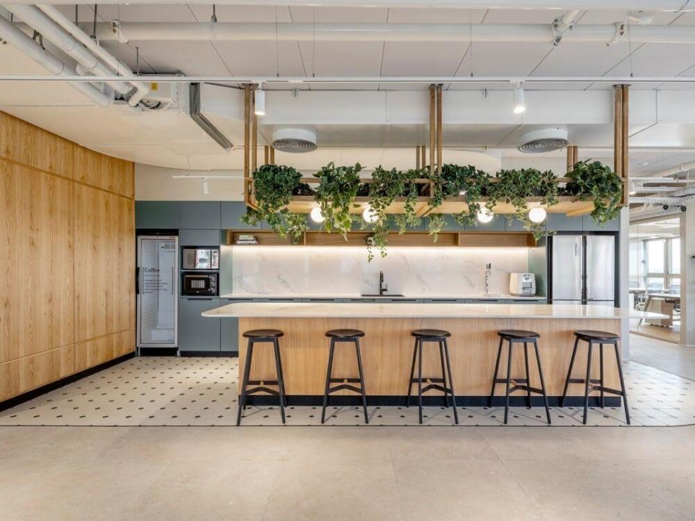 Pantry văn phòng ấm cúng thoải mái với tủ bếp và khu bàn ghế thư giãn