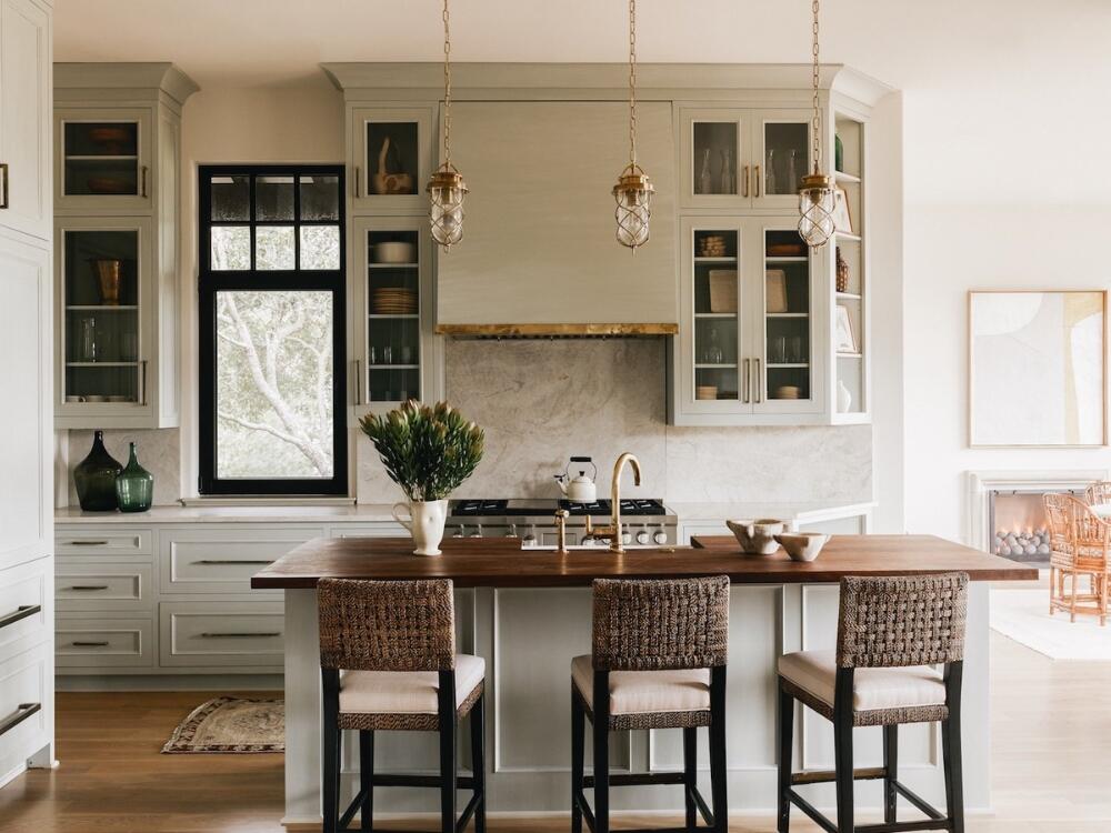 Phòng bếp thoáng sáng với ghế tre và mặt bàn gỗ sáng màu mang lại cảm giác gần gũi biển cả