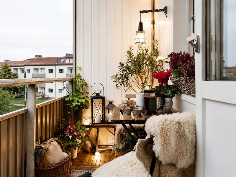Thiết kế ban công chung cư Vintage với bàn ghế gỗ, đèn kiểu cổ và chậu cây