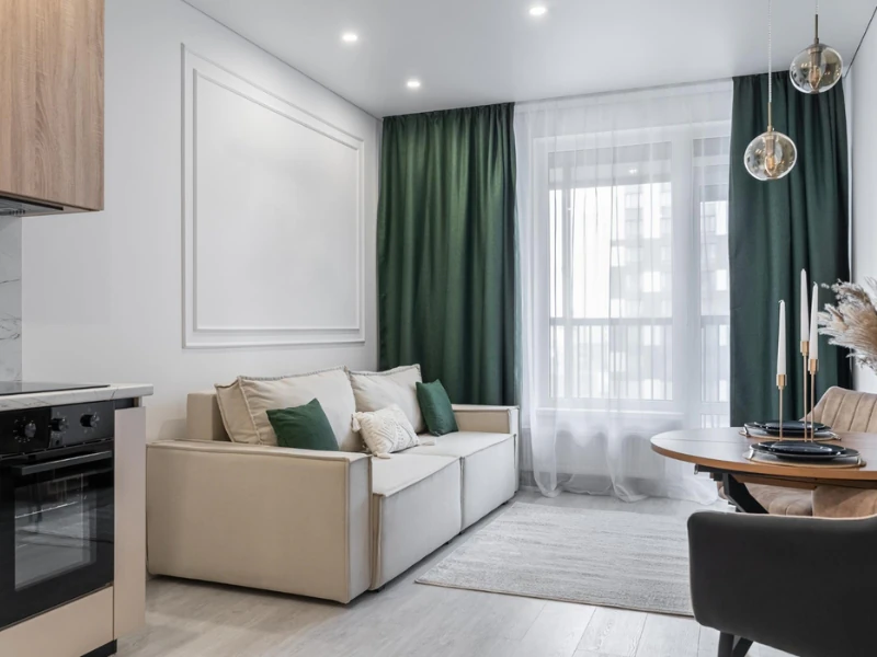 Căn hộ 3 phòng ngủ theo phong cách tối giản với sofa be, rèm xanh và bàn ăn tròn