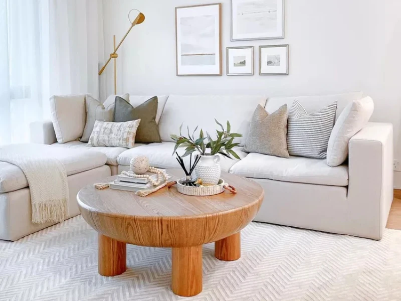 Phòng khách chung cư tối giản với sofa chữ L và bàn trà gỗ tròn