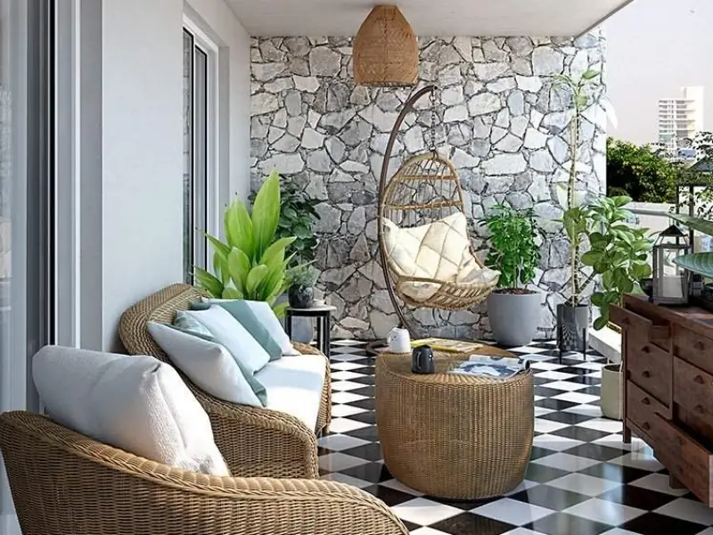 Thiết kế ban công chung cư với bàn ghế mây và xích đu tạo góc thư giãn
