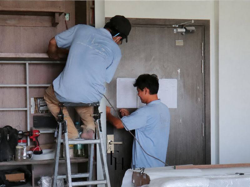 Kỹ thuật viên FHome Sài Gòn đối chiếu bản vẽ và lắp đặt hệ tủ gỗ tại căn hộ