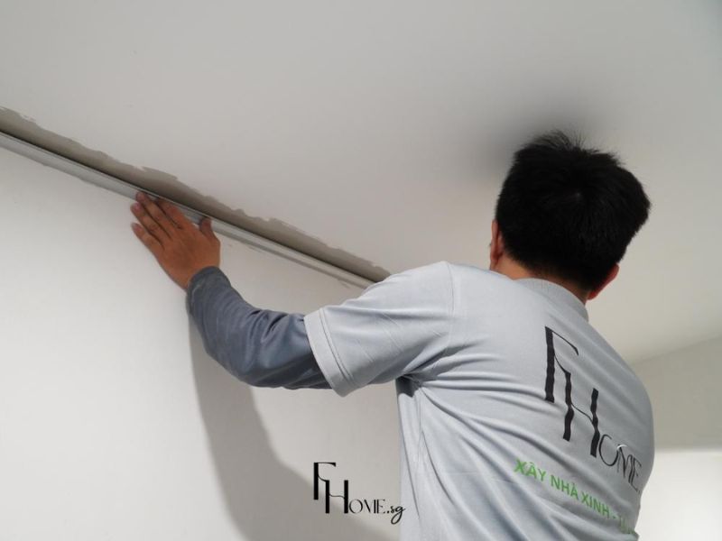 Kỹ thuật viên FHome Sài Gòn tỉ mỉ lắp đặt thanh nẹp viền trần thạch cao cho căn hộ