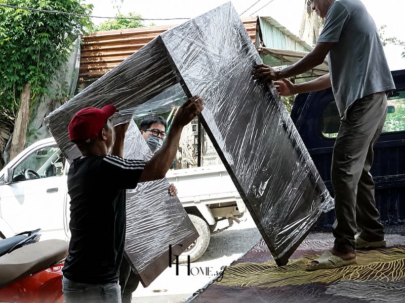 Nhân sự FHome vận chuyển cấu kiện đồ nội thất bọc màng bảo vệ từ xe tải đến căn hộ