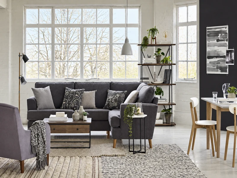 Phòng khách chung cư 20m2 với sofa xám, cửa sổ lớn và kệ trang trí.