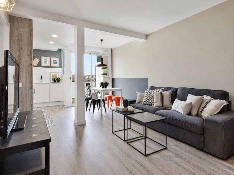 Phòng khách chung cư 60m2 với sofa nỉ, bàn trà kép và cột gỗ ngăn không gian.