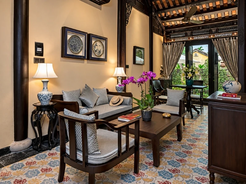 Phòng khách chung cư với nét đẹp miền Trung với sofa gỗ tối màu, gốm sứ xanh trắng.