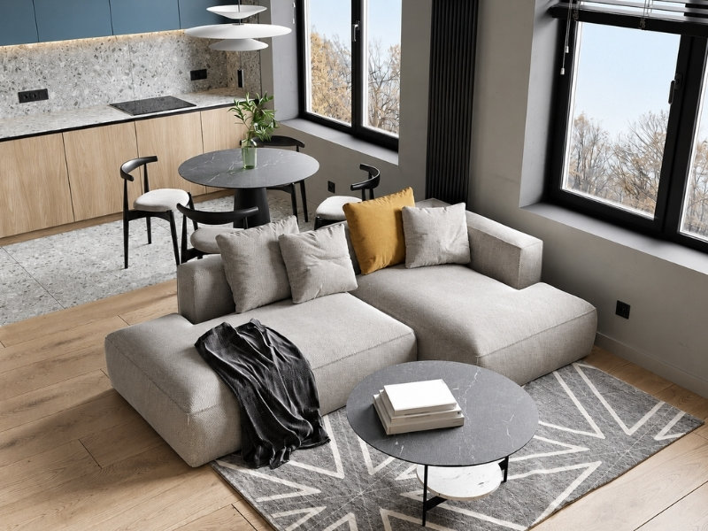 Phòng khách căn hộ 40m2 với sofa module, bàn tròn, cửa sổ lớn và bếp liền kề