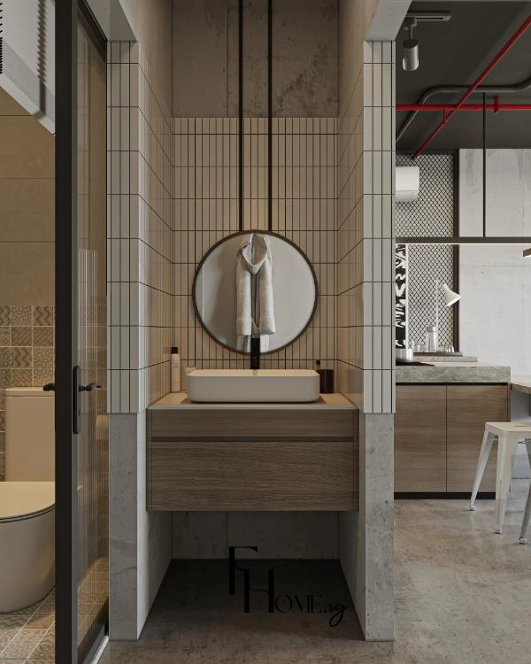 Lavabo trong hốc gạch thẻ trắng với gương tròn viền đen và tủ gỗ treo