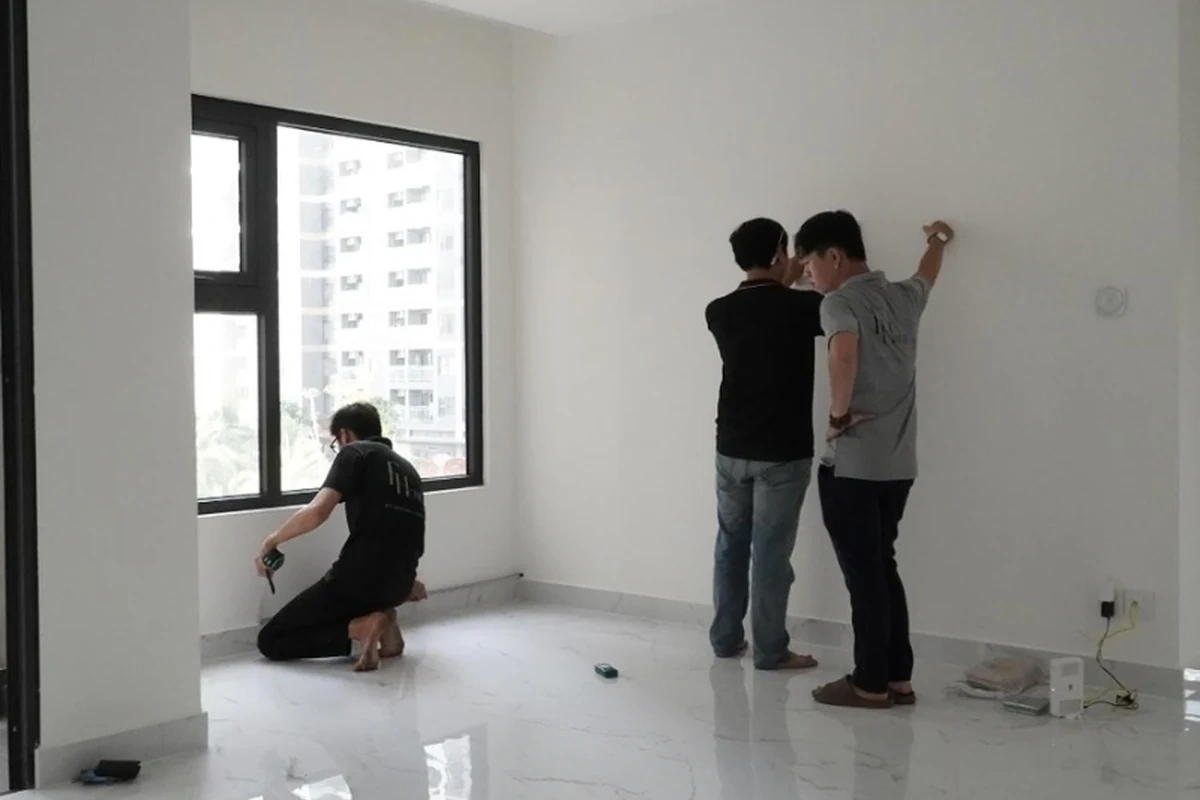 Đội ngũ thi công kiểm tra kích thước tường và sàn căn hộ trước hoàn thiện