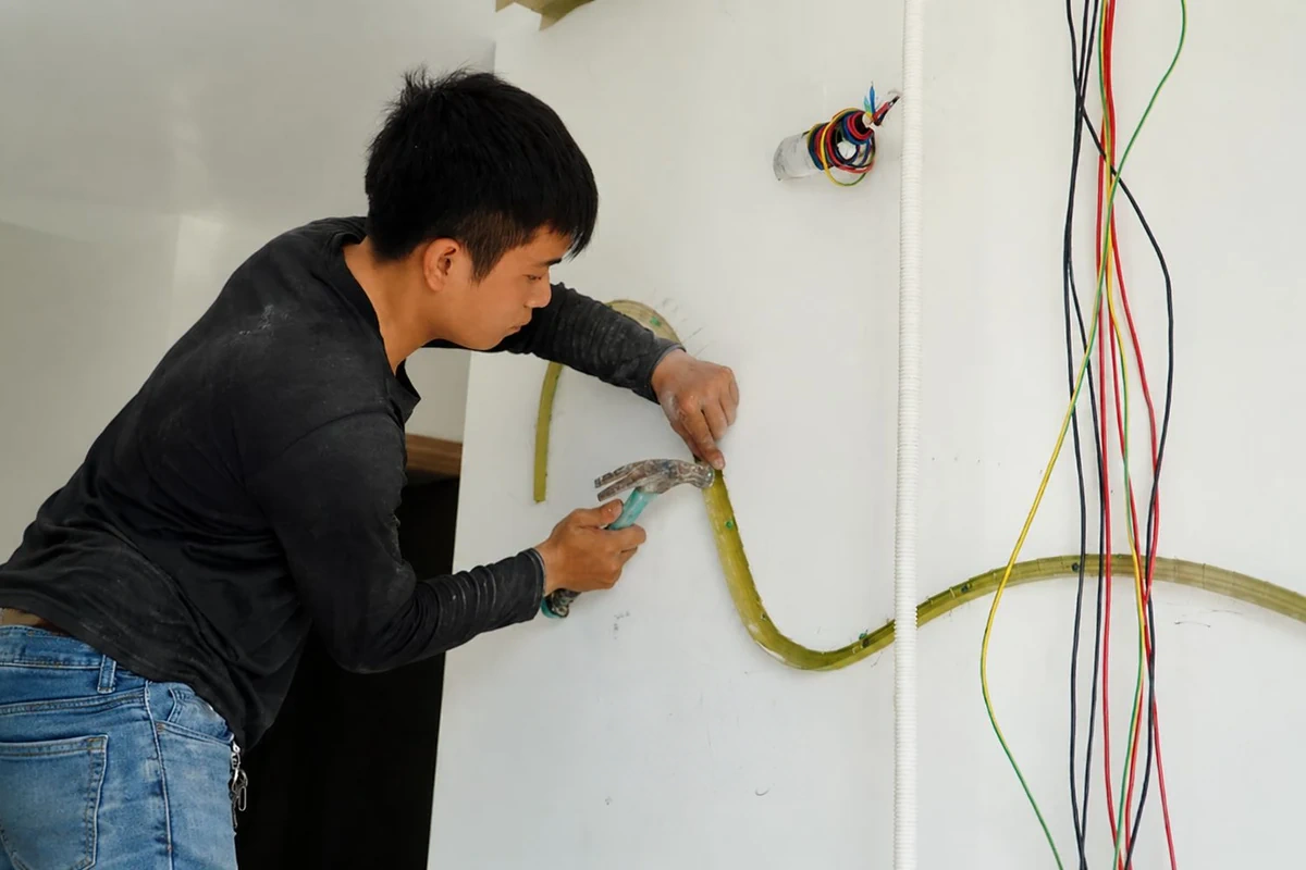 Thợ đo đạc và lắp đặt đường dây điện nước âm tường trong căn hộ